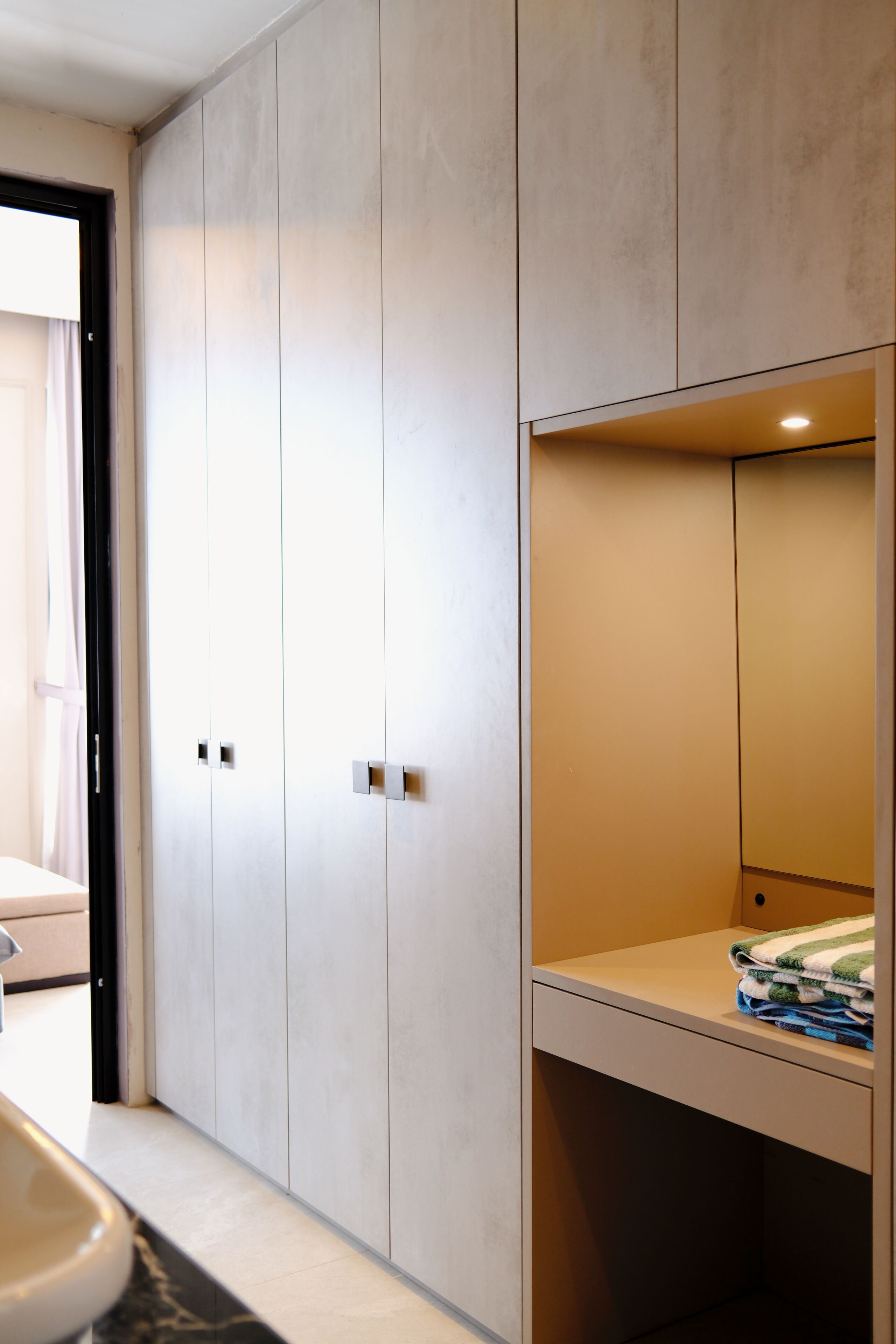 A modern bathroom with a sink, mirror, and light-colored cabinets.