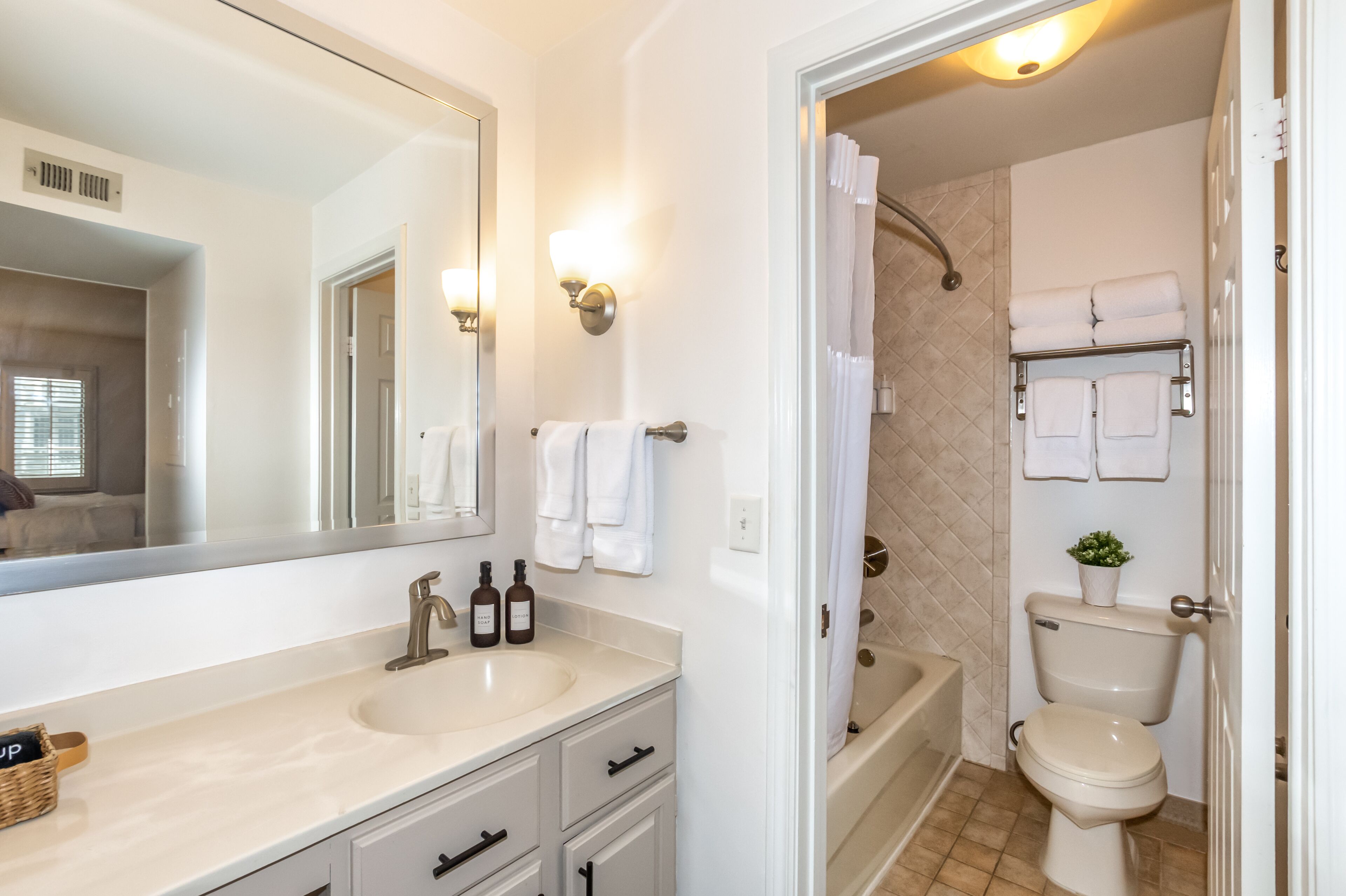 A bathroom with a sink, mirror, towel rack, and toilet.