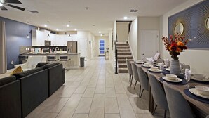 Eine moderne Küche mit weißen Schränken, einer eingebauten Mikrowelle und einer grauen Arbeitsplatte.