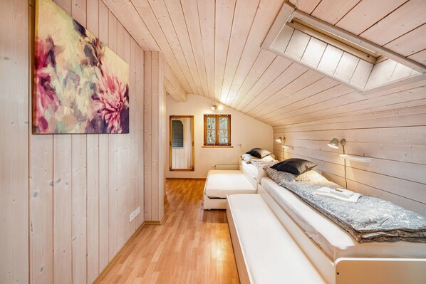 Ein gemütliches Blockhaus mit Holzwänden, einem Schlafzimmer auf dem Dachboden, einer Bank und einem Gemälde.