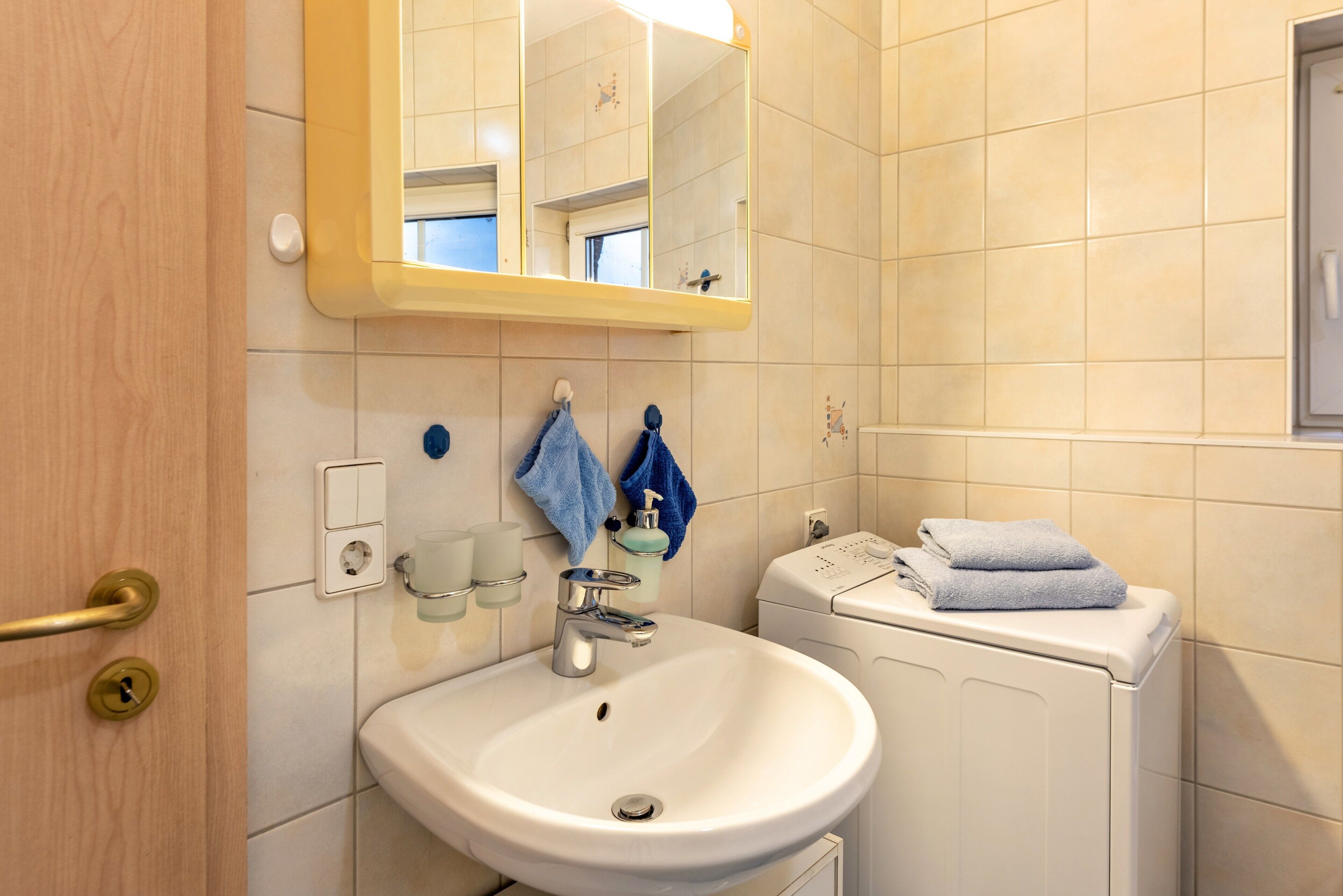 Une salle de bain équipée d’un lavabo, d’un miroir, d’un porte-serviettes et de toilettes.
