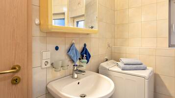 Une salle de bain équipée d’un lavabo, d’un miroir, d’un porte-serviettes et de toilettes.