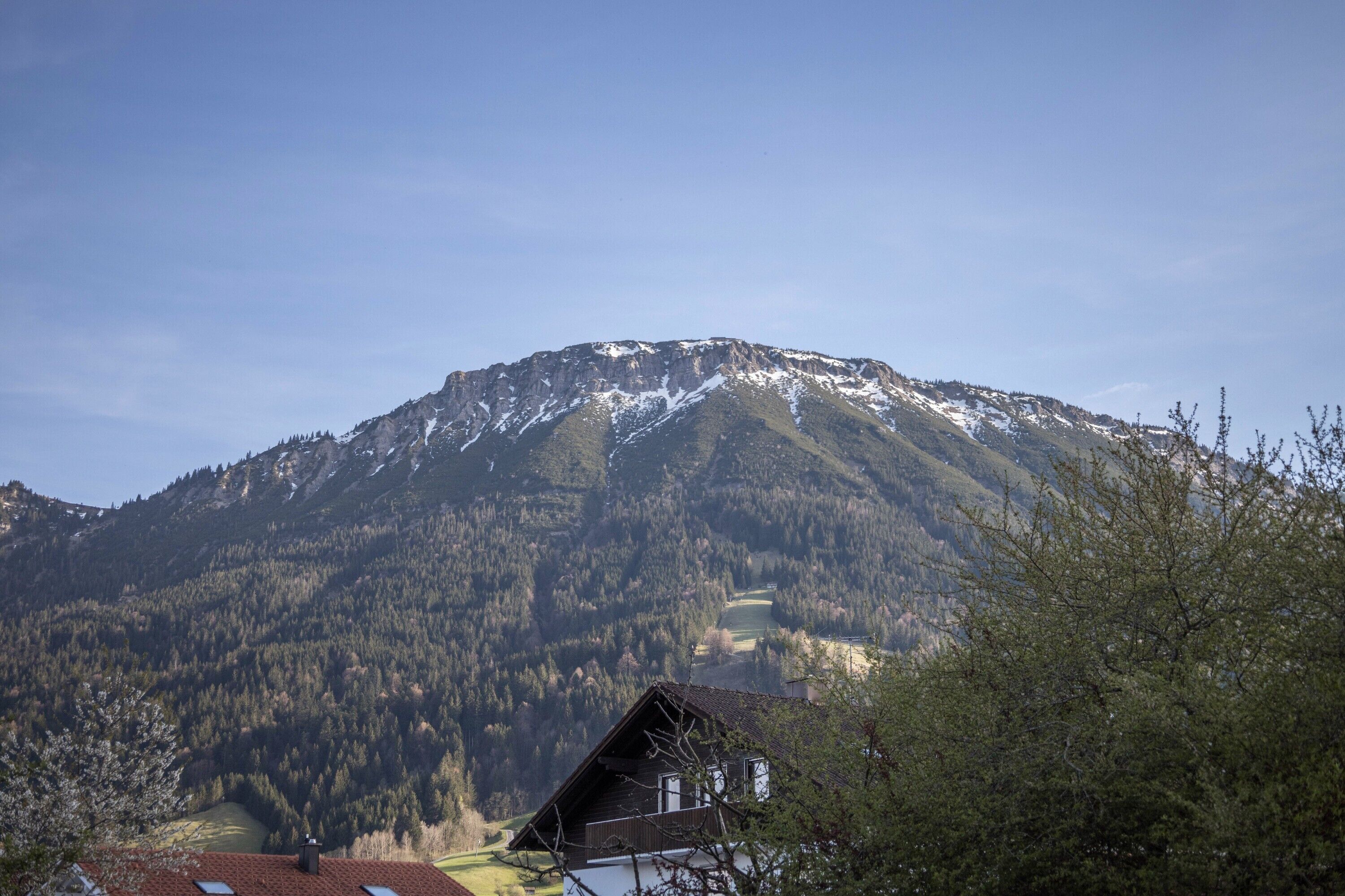 A mountain with a house in the foreground.
