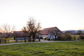 A large house with a red roof, surrounded by a grassy field and trees. - Chalet "Windhäusern 5" with Mountain View, Shared Garden & Wi-Fi (Wangen im Allgäu)