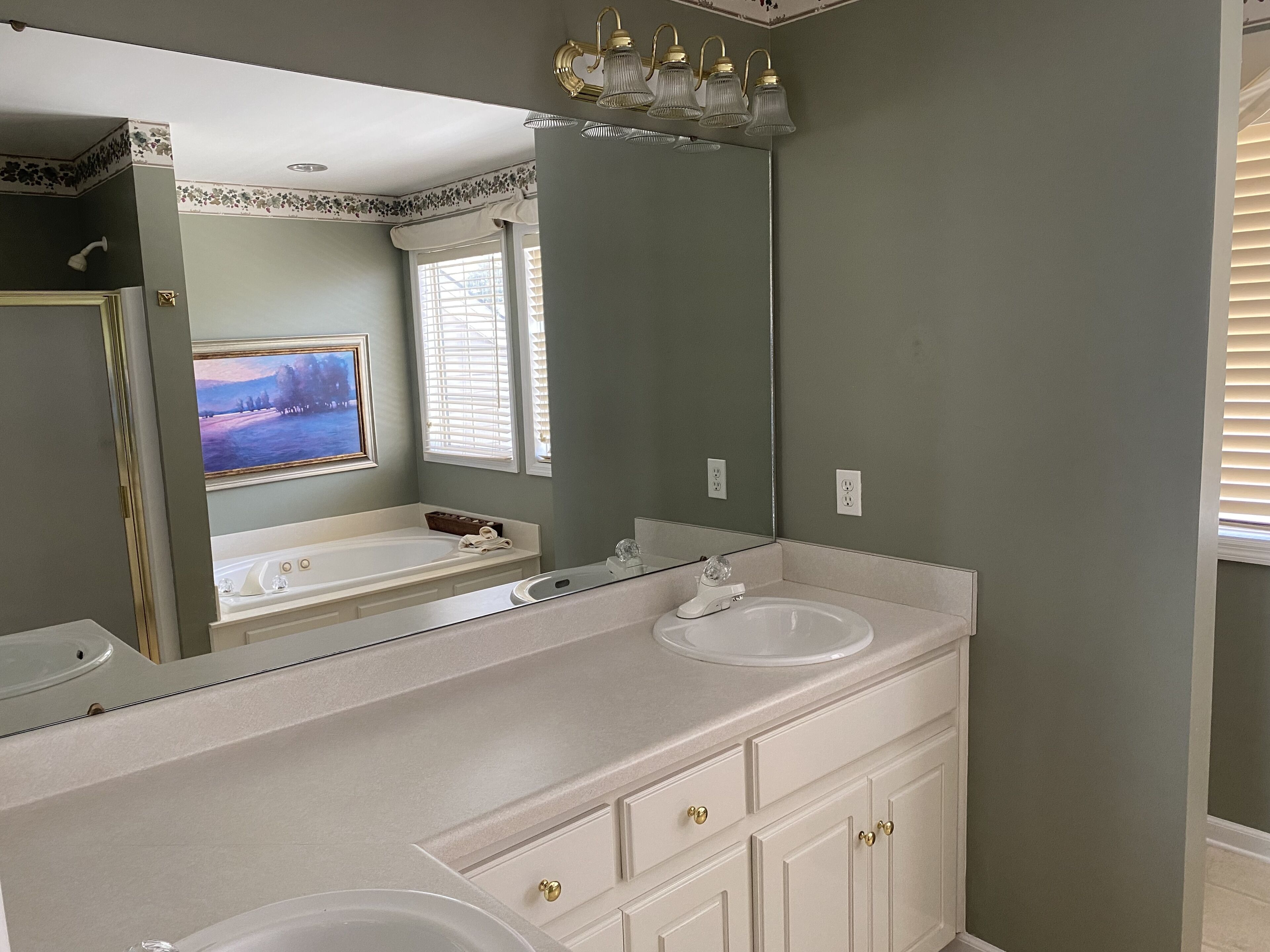 Un bagno con doppio lavabo, una vasca e un ampio specchio.