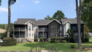 A multi-story building with a covered walkway leading to a dock over water. - Beautiful 2BR/2.5 BA - Lakefront, Private Dock & Boat Ramp. Starlink Internet. (Abbeville)