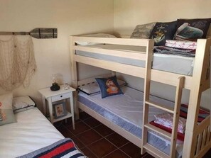 A bunk bed room with a small bedside table, a lamp, and a framed picture. - Villa Orchard View in Chiclana (Chiclana)