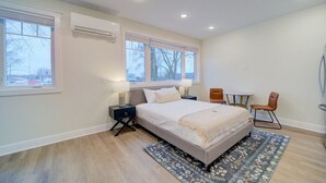 Une chambre à coucher moderne avec un grand lit, deux tables de chevet, une petite table et une chaise.