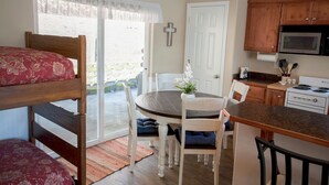 A compact kitchen with a dining table, chairs, a microwave, and a sink. - A beautiful Retreat on beautiful Hayden Lake nestled among the gorgeous pines (Hayden)