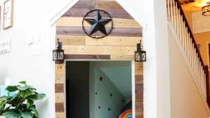 Une salle de jeux décorée avec des motifs en forme d’étoile, un ballon aux couleurs de l’arc-en-ciel et une plante en pot.