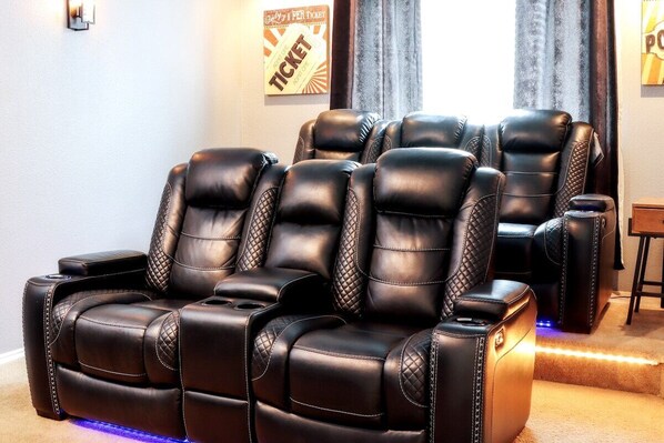 A massage chair area with multiple black leather massage chairs, a small table, and a wall-mounted sign.