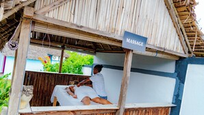 Un salón de masajes con estructura de madera y un letrero que indica que ofrece masajes.