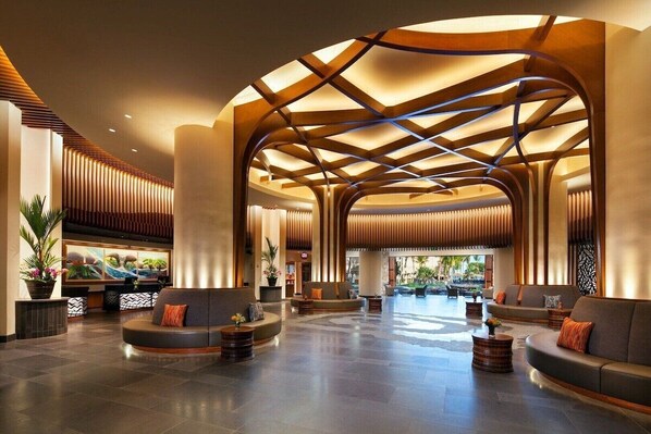 Experience the inviting atmosphere of our lobby, featuring a curved reception desk and comfortable seating areas.