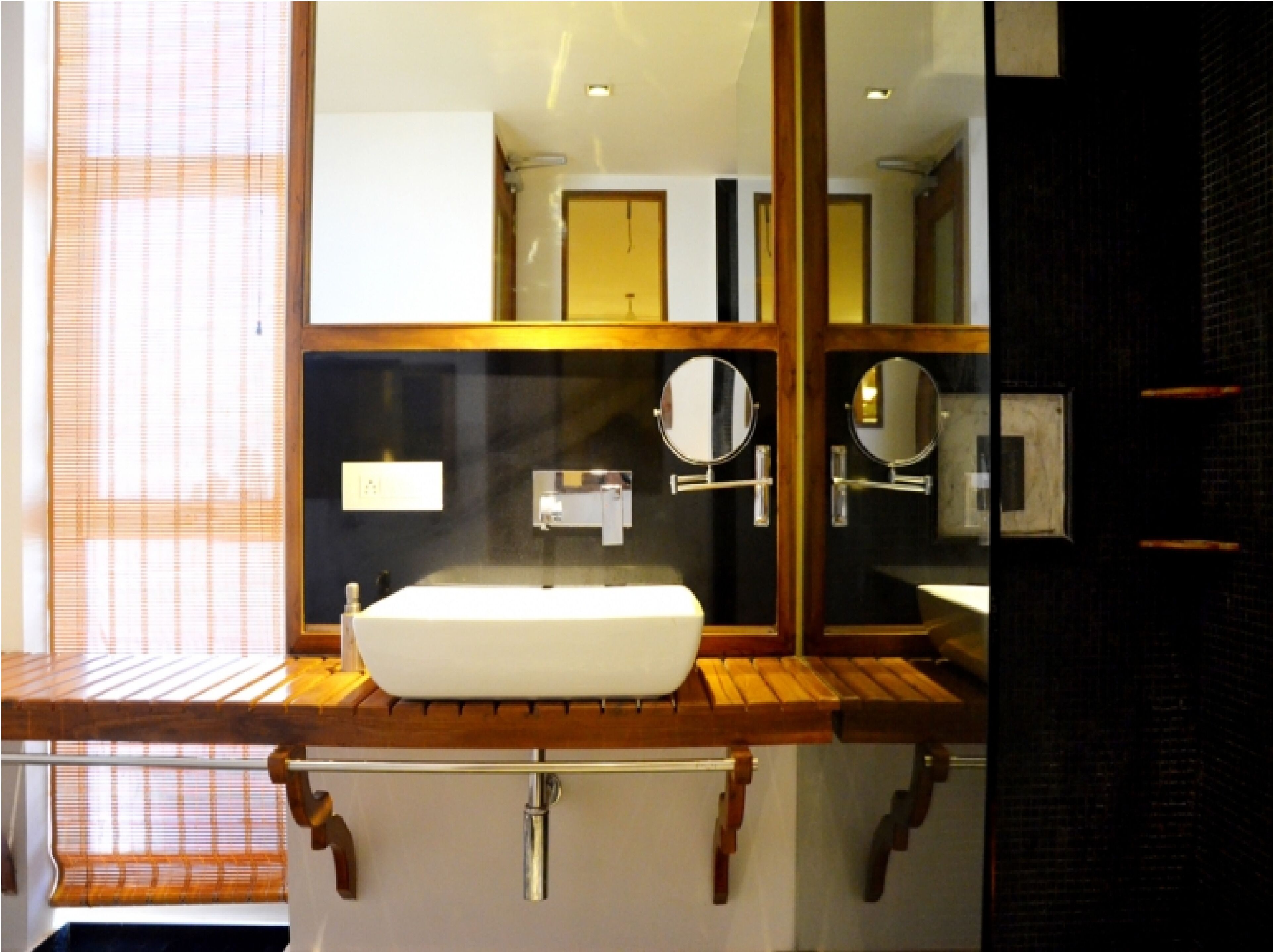 Une salle de bain avec un meuble-lavabo en bois, un lavabo blanc et un miroir.