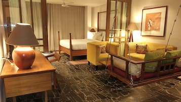 Una habitación de hotel con una cama, un sofá, un escritorio y una lámpara de pie.