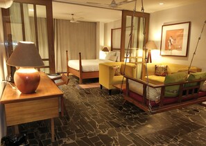 A hotel room with a bed, a sofa, a desk, and a standing lamp. - The Sky Imperial Aarivaa Luxury Homestay (Rajkot)