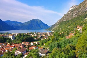 A mountainous town with a lake, surrounded by greenery and red-roofed buildings.