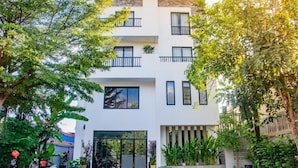 A modern multi-story building with balconies, large windows, and a well-maintained garden area. - Angkor Vattanakpheap Villa (Siem Reap)