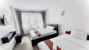 A hotel room with two beds, a desk, and a window with curtains. - Angkor Vattanakpheap Villa (Siem Reap)