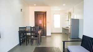 A modern living room with a dining area, a sofa, and a kitchen in the background. - Angkor Vattanakpheap Villa (Siem Reap)