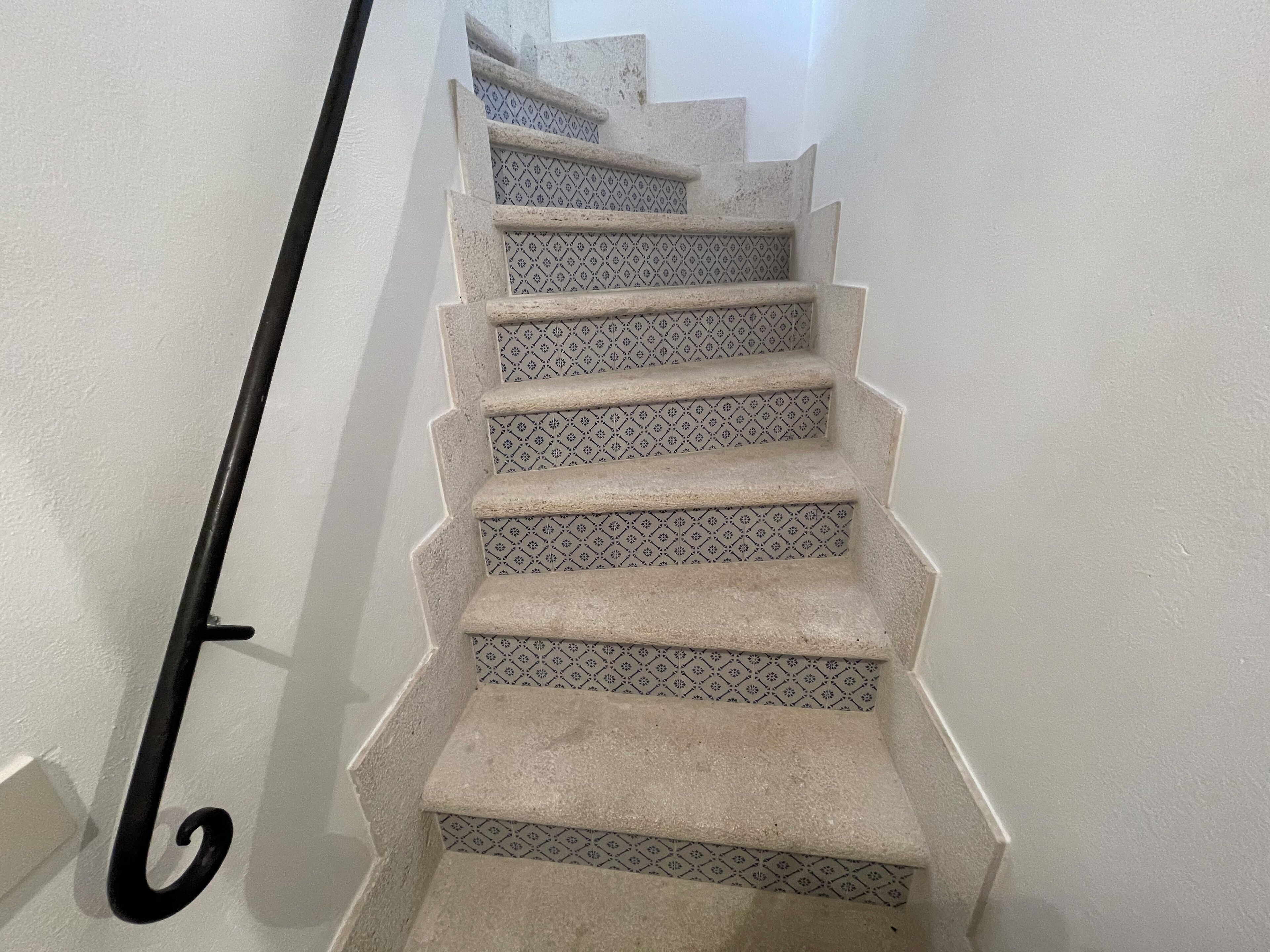 Una escalera con peldaños estampados y barandilla negra.