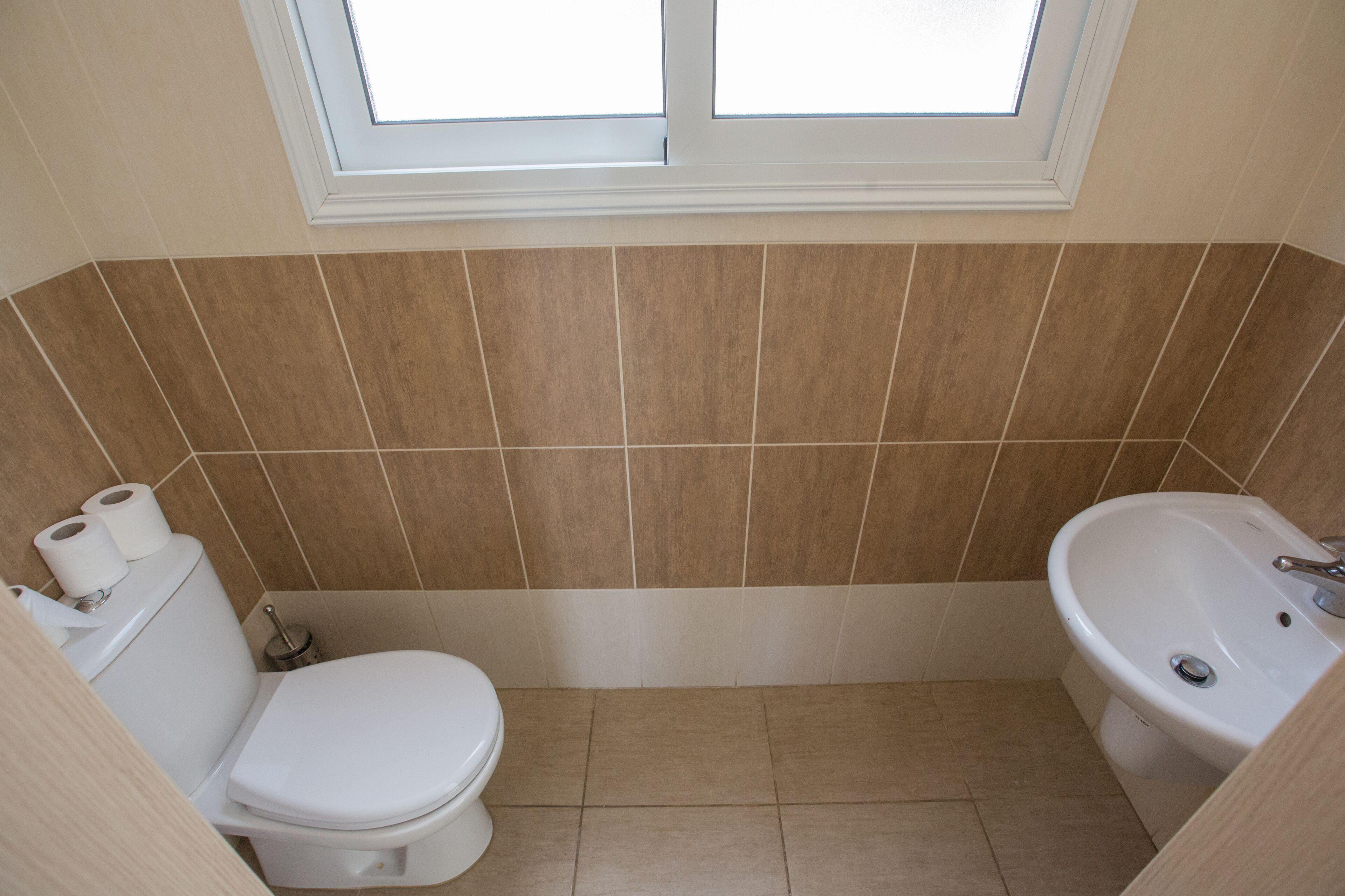 Un bagno con il water, un lavandino e una finestra.