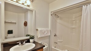 Un baño con lavamanos, espejo y bañera.