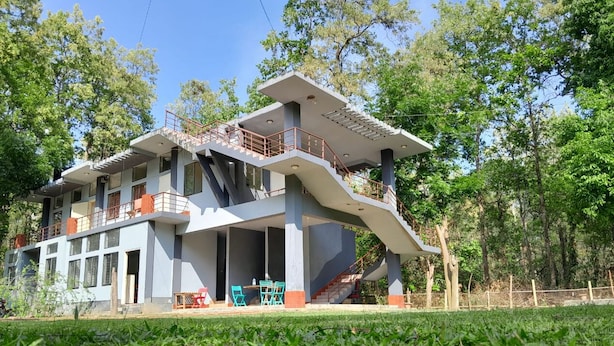 Un edifici modern de dues plantes amb teulada plana, múltiples balcons i una escala que condueix a la planta superior.