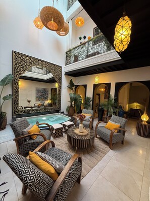 A spacious indoor area with patterned furniture, a pool, and decorative lighting. - Magnificent Riad Julilu Privatise in the heart of the Medina (11P) (Marrakech)