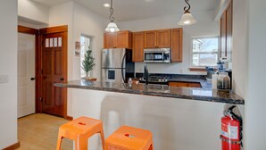 A modern kitchen with wooden cabinets, stainless steel appliances, and a granite countertop.