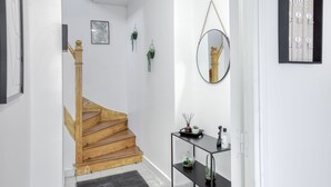 A staircase with wooden steps and a golden handrail leading to a landing. - House 8 persons - Subway + train station / Private parking lot / Wifi / CDG airport / (La Courneuve)