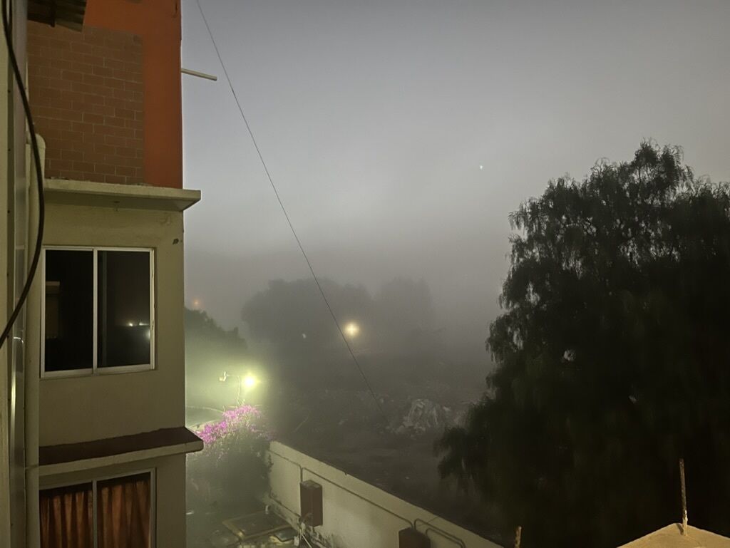 Un edificio residencial con balcón, ventana y vista a la calle.