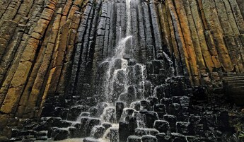 Una cascada que se precipita por un acantilado rocoso.