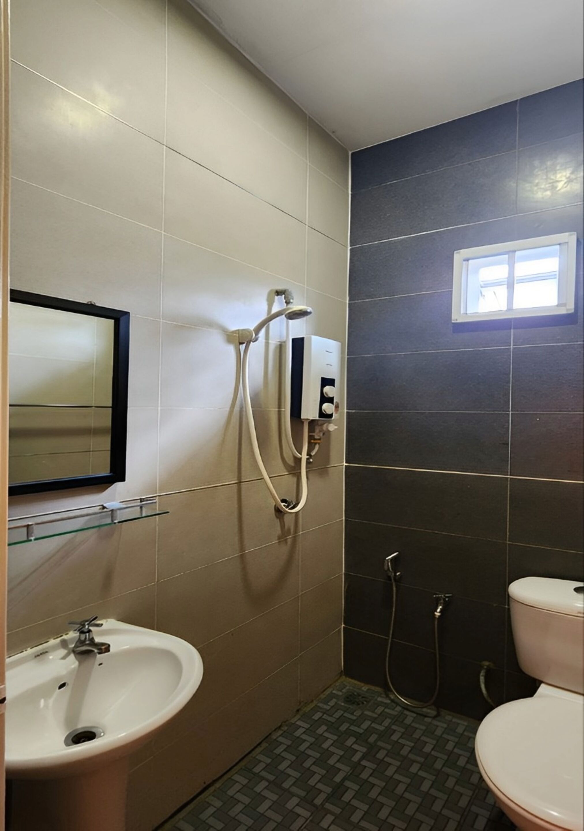A bathroom with a sink, mirror, and toilet.