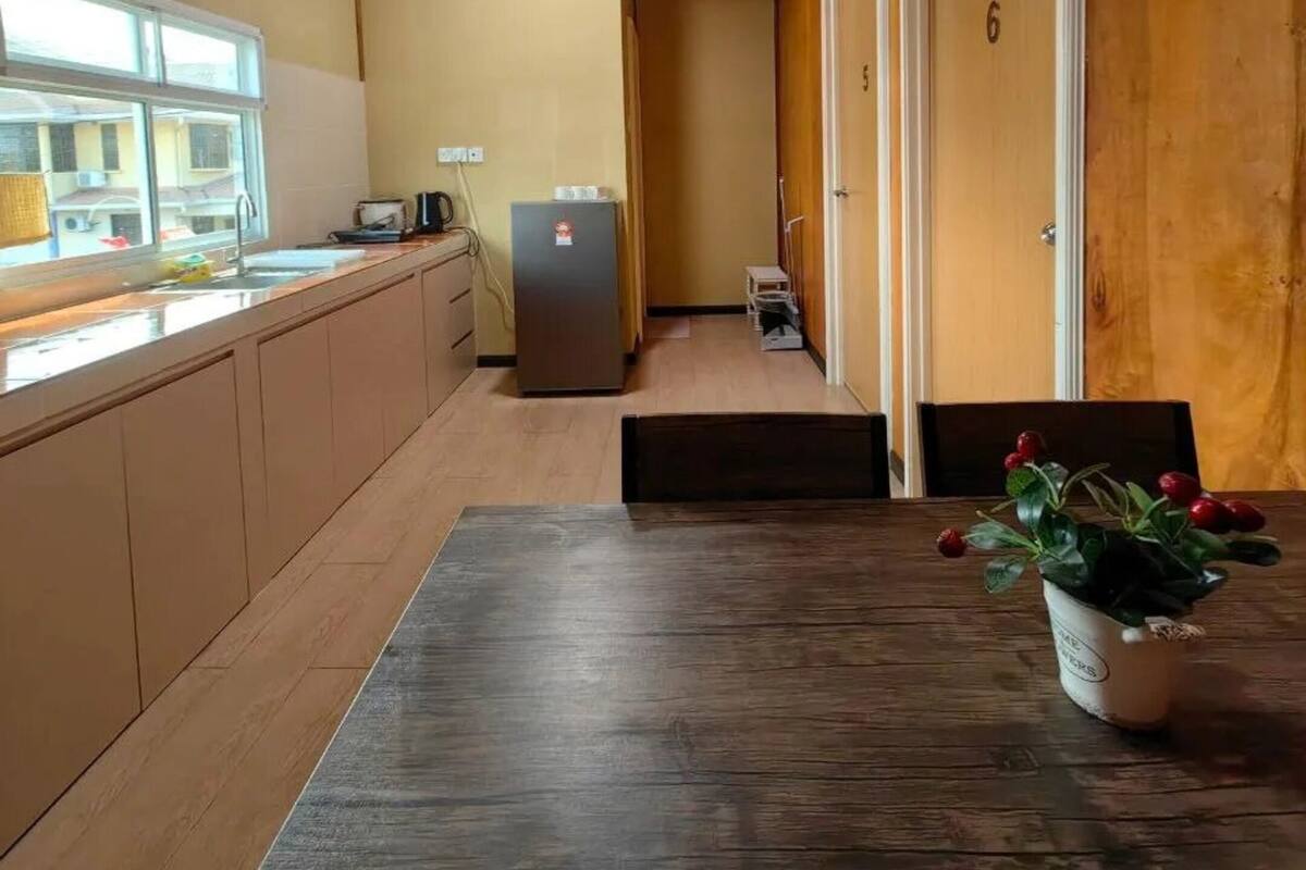 A kitchen with wooden cabinets, a refrigerator, a ceiling fan, and a window.