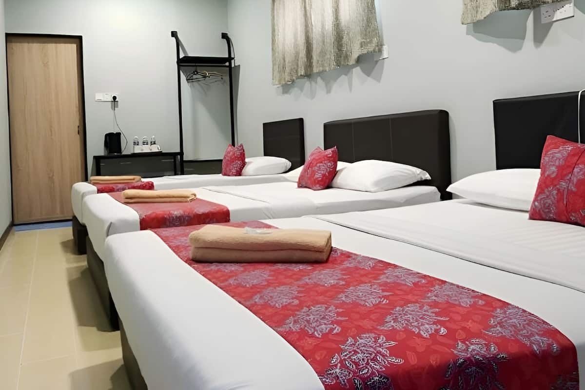 A hotel room with two beds, a wardrobe, a bedside table, and a window with curtains.