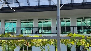A covered outdoor area with a bench and a railing. - Grapevine Garden (Kota Kinabalu)