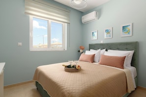 Quarto com cama, janela, ar condicionado e decoração na parede.