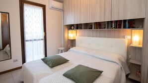 Ein Schlafzimmer mit Bett, Nachttischlampen, einem Spiegel und einem Kleiderschrank.