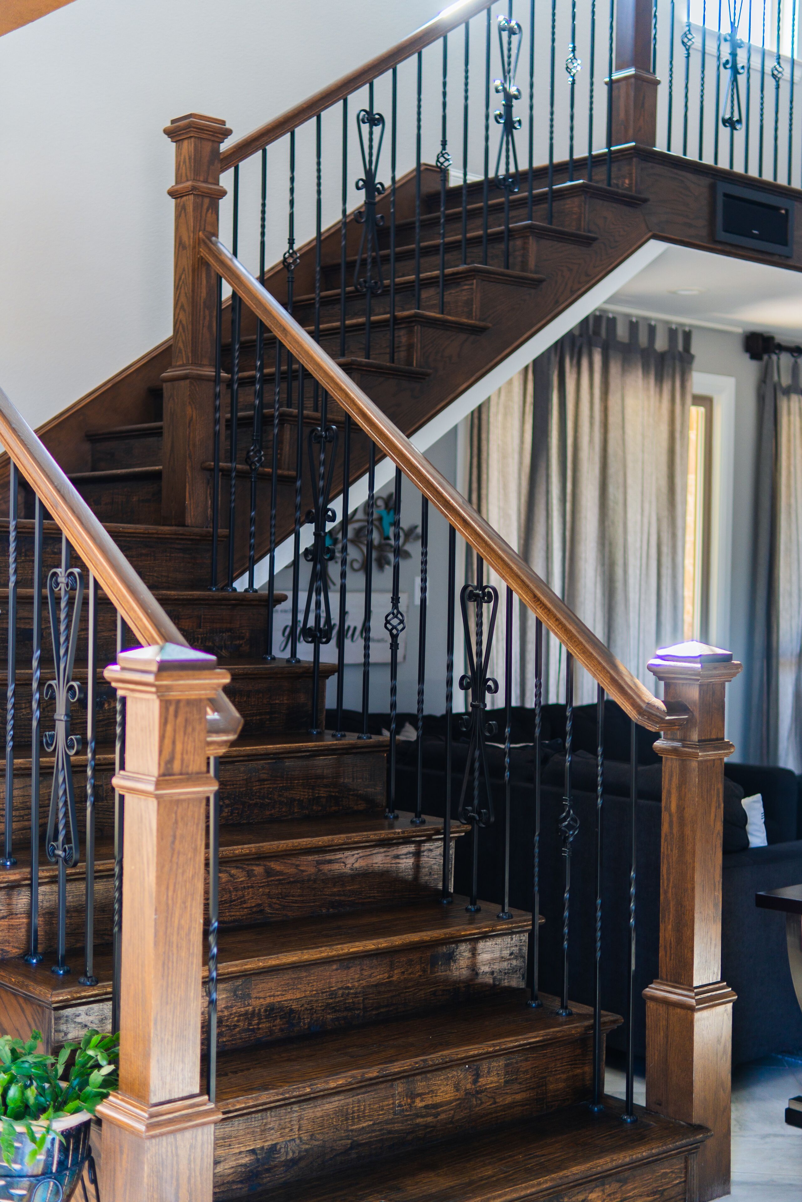 A wooden staircase with black metal railings and a wooden handrail.