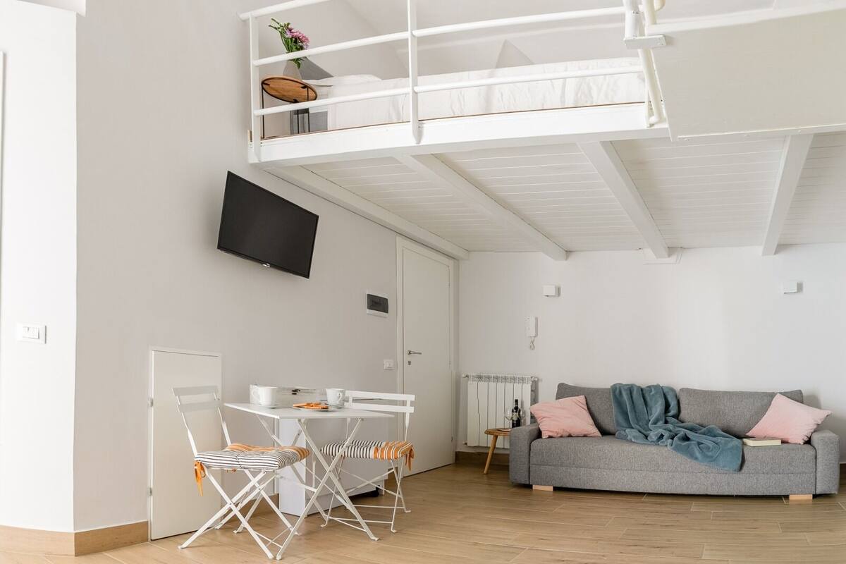 Un apartamento moderno con habitación en altillo, comedor y sala de estar.