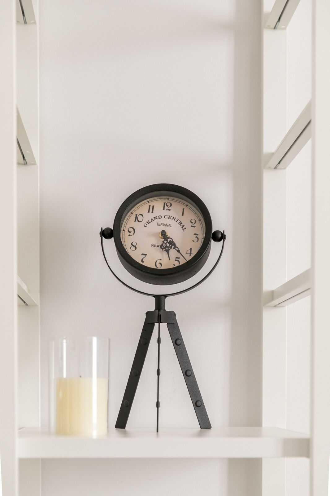 Une horloge murale au design rétro, portant l’inscription « Grand Central Terminal », est posée sur une étagère blanche.