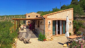 A stone building with a patio area, outdoor seating, and a pergola.