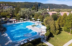 Relax by the rectangular pool surrounded by lush greenery and rolling hills.