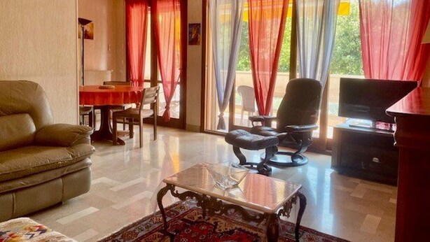 A living room with a sofa, a coffee table, a TV, and a dining area with a table and chairs. - Bright F2 Apartment with Terrace, Parking, and WiFi in Amélie-les-Bains (Amélie-les-Bains-Palalda)