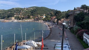 A beach in Theoule with boats docked, a promenade, and buildings on a hillside. - Fabulous 5 Bedroom Villa near Cannes perfect for the Lions Festival. 
 (Théoule-sur-Mer)