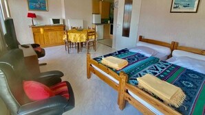 Une chambre à coucher avec un lit, une tête de lit en bois, une chaise, un bureau et une table à manger.