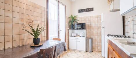 Microondas, cafetera/tetera, utensilios de cocina, mesa de comedor