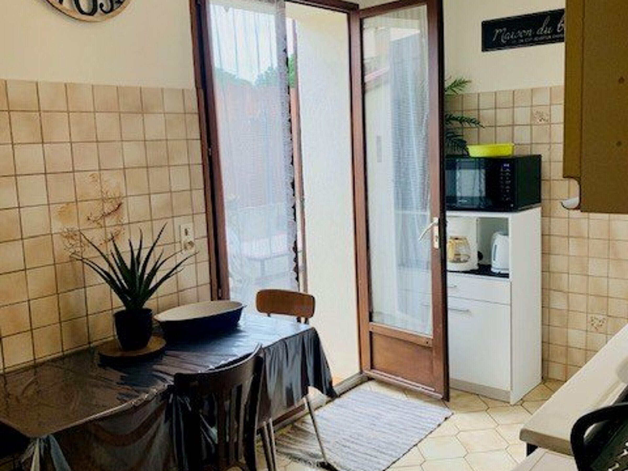 A compact kitchen with a dining area, a microwave, and a small refrigerator.