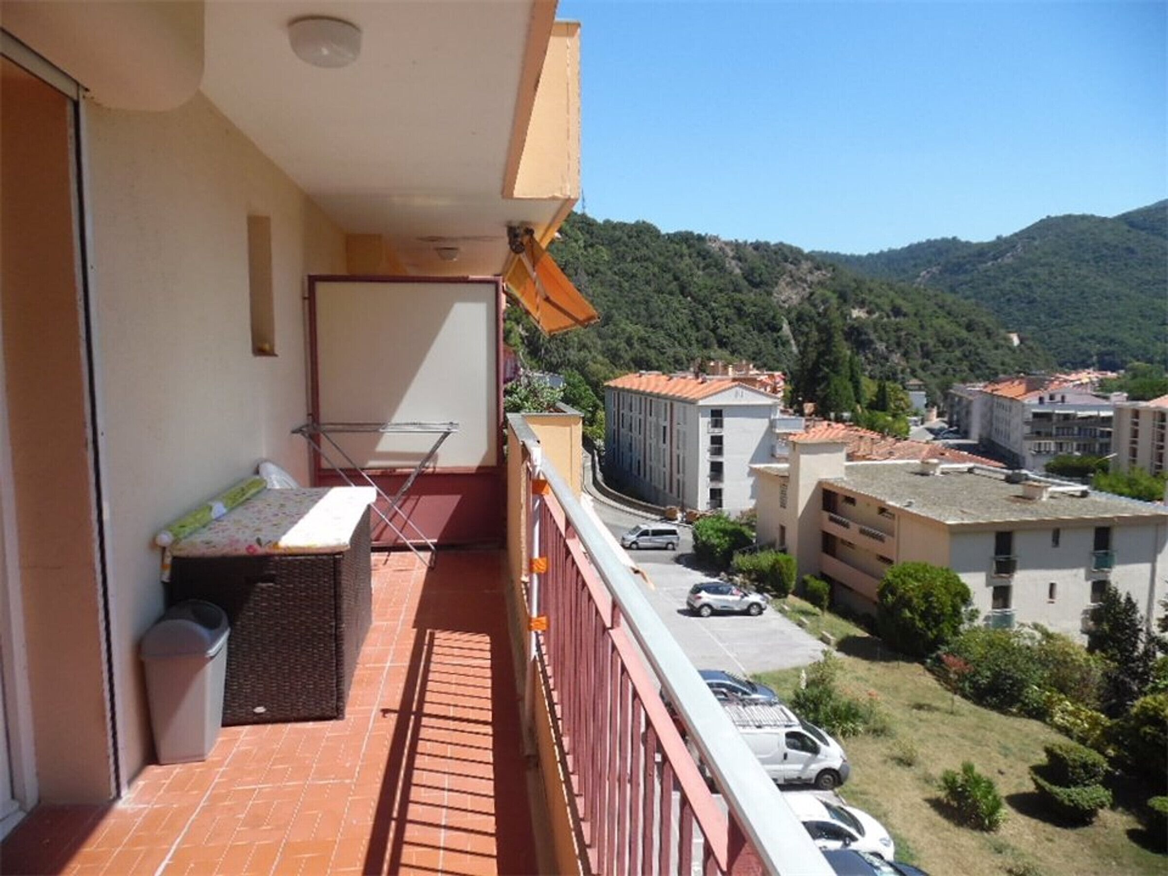 Ein Balkon mit einem kleinen Tisch, einem Stuhl und einer Wäscheleine.